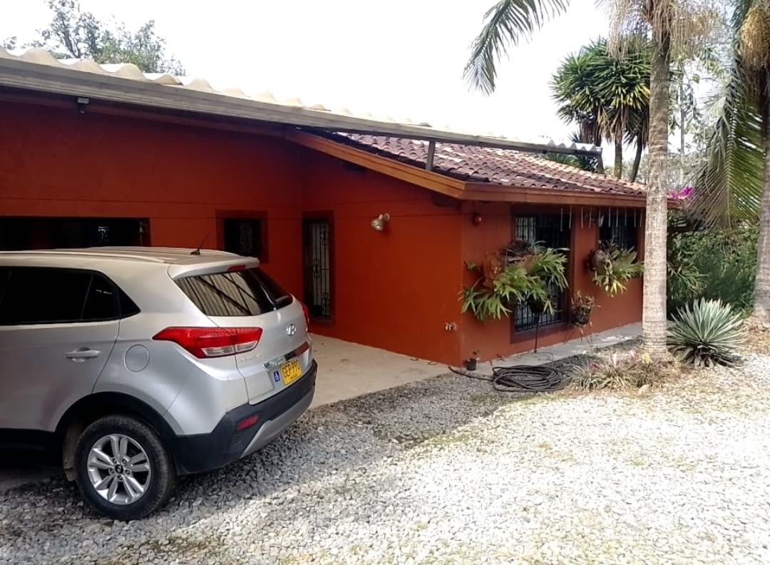 Acceso en grava y fachada de la vivienda principal